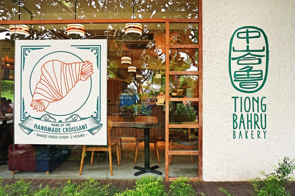 Tiong Bahru Bakery café exterior showcasing handmade croissant poster and cozy wooden interior in Singapore