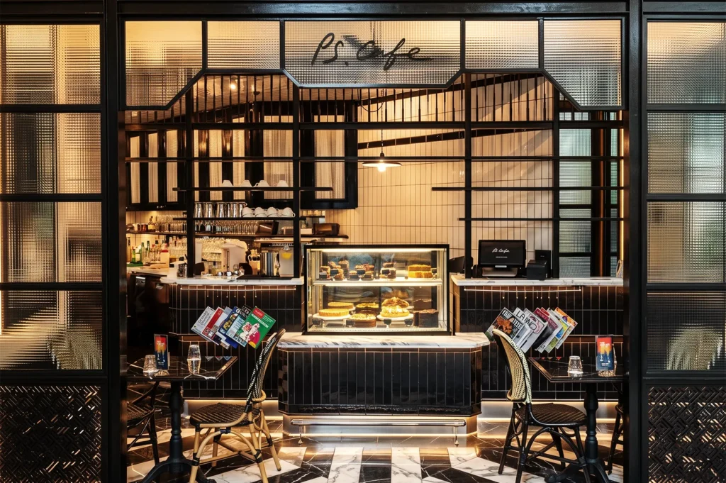 Chic PS.Cafe Singapore with black‑and‑white marble flooring, glass partitions, and dessert display featuring cakes and pastries.